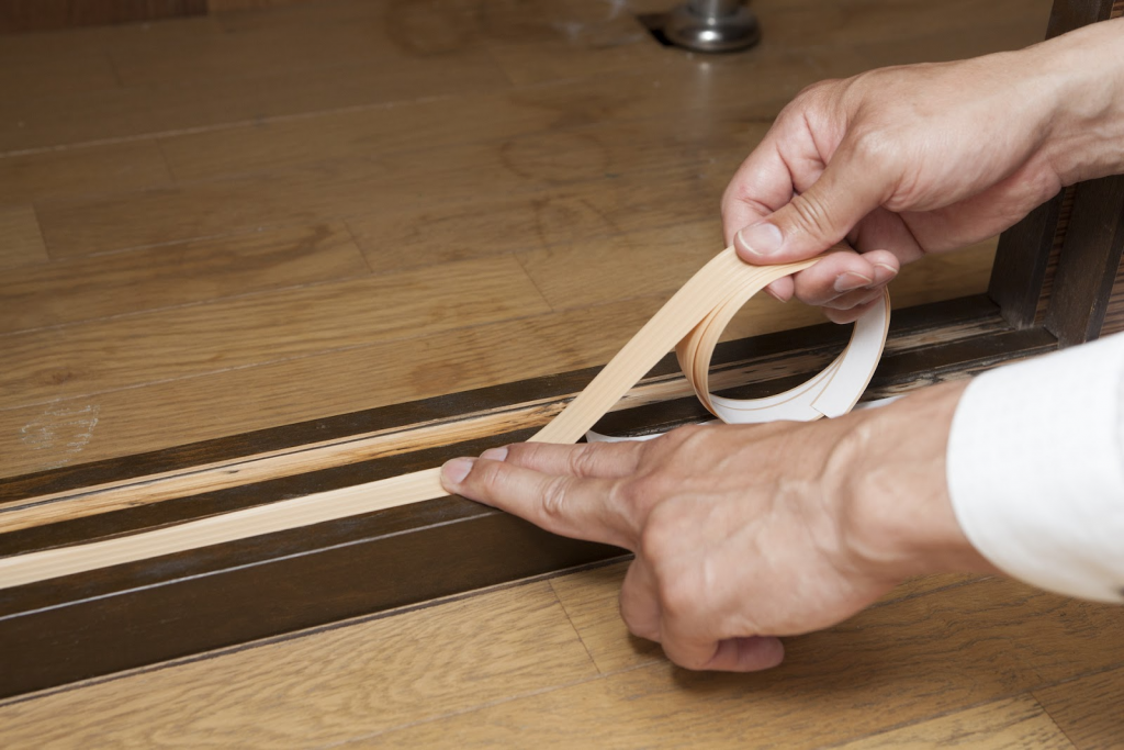敷居に敷居すべりテープを貼る作業