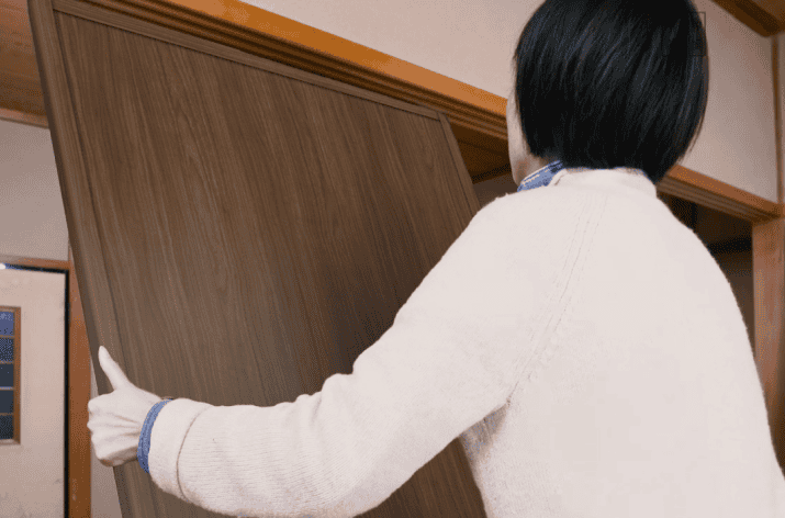 女性がふすまミゾに、引き戸を取り付ける様子