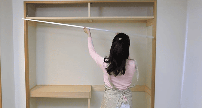 押入れの上溝にクローゼット用のレールと取り付けている様子