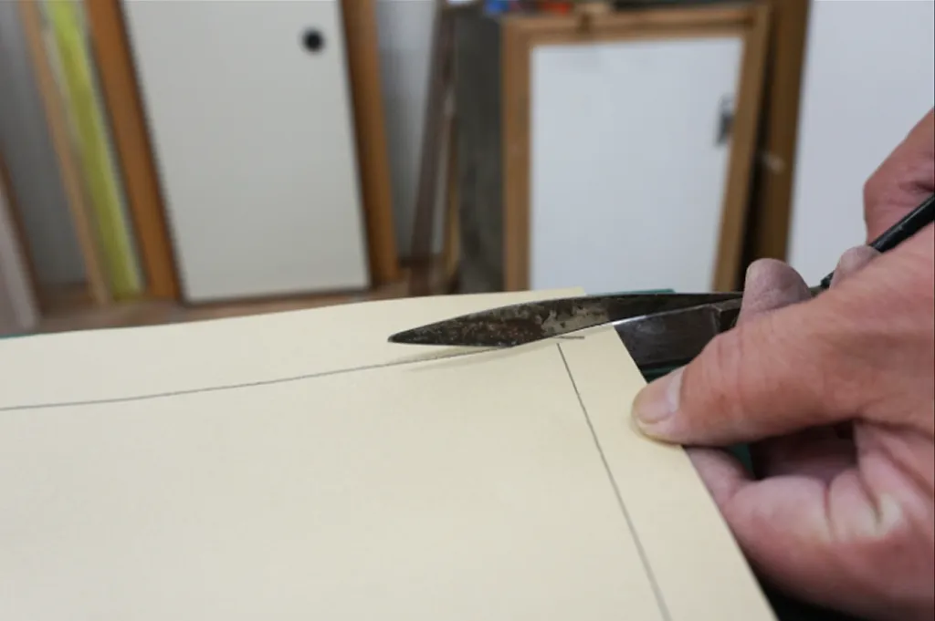 step1で引いた線に沿って、ハサミでふすま紙をカットしている様子