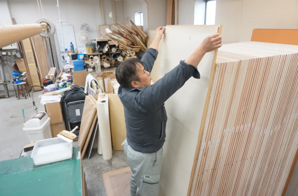 襖の張り替え|新しい襖紙を襖本体に貼り付けている作業写真