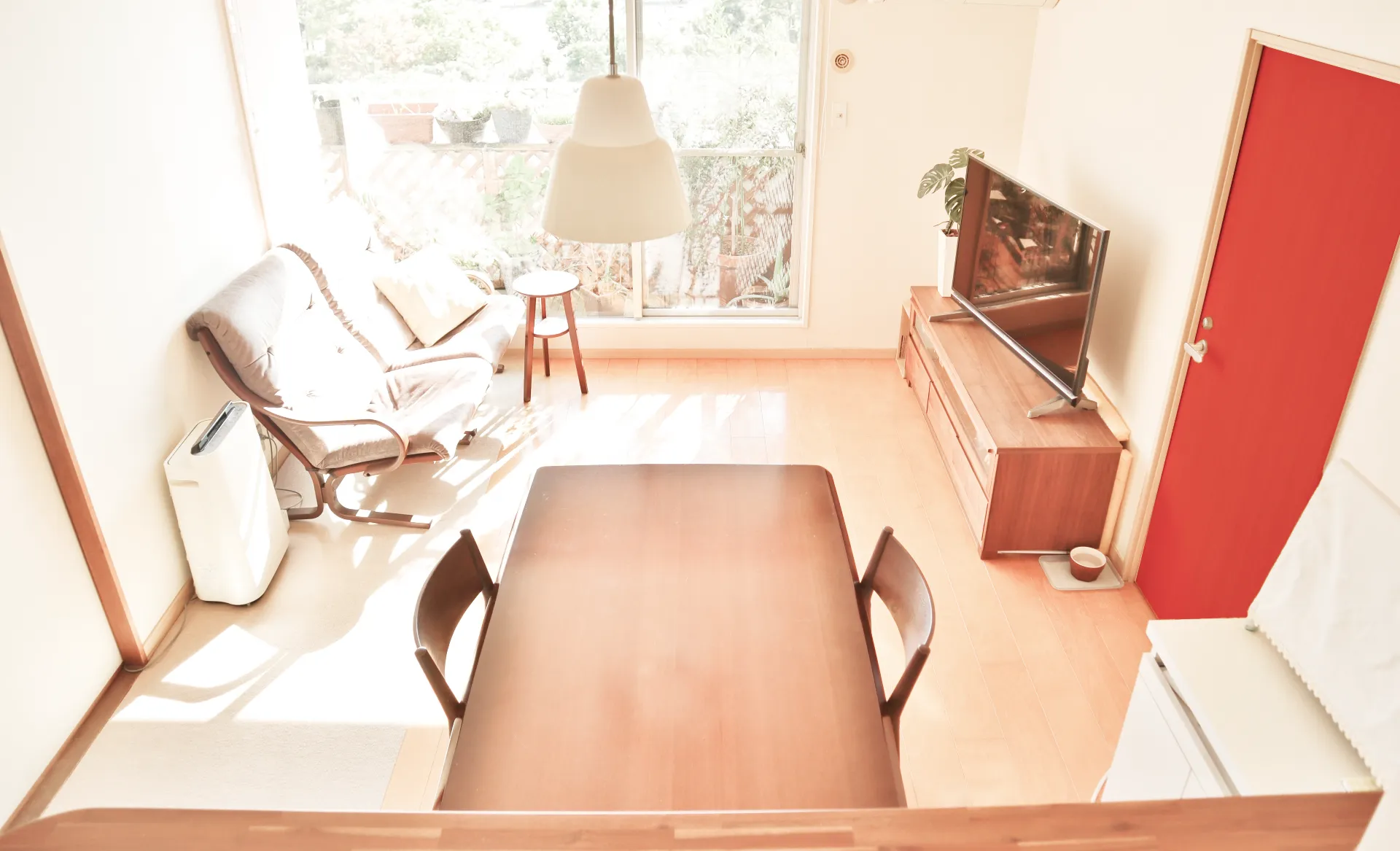 赤い室内ドアがアクセントになった明るいリビング