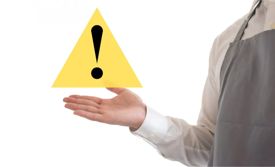 注意マークを手の上に示す人物