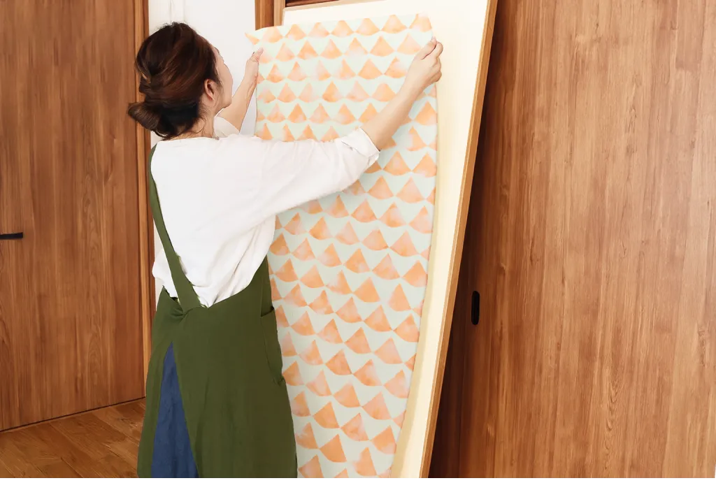 クロスを貼る女性